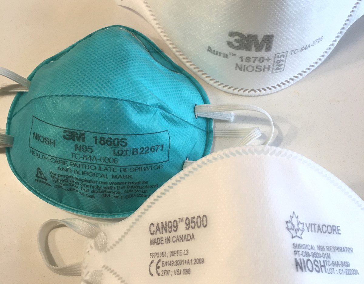 Photo of three white and blue N95 respirators.