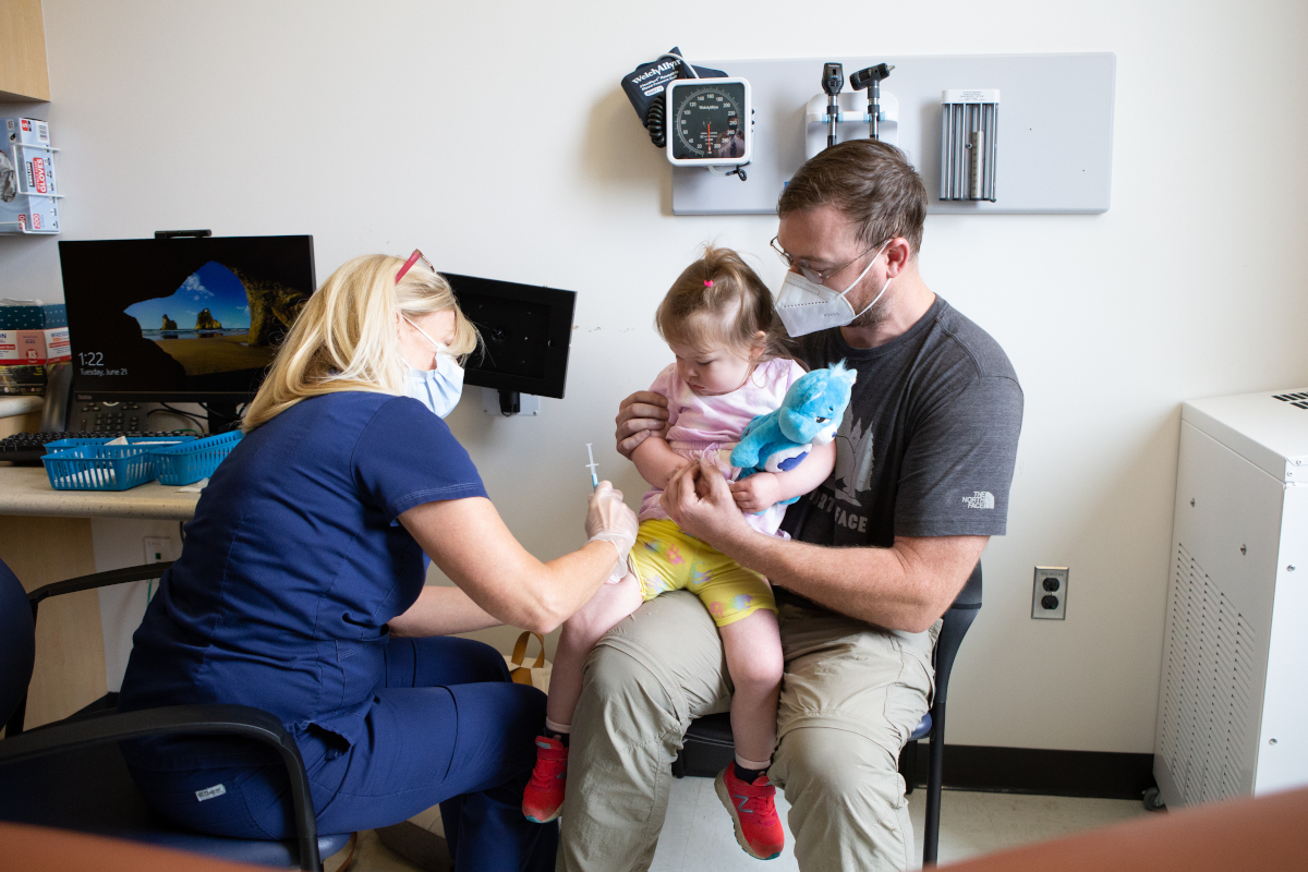 A young child receives a dose of a COVID-19 vaccine at a vaccine clinic in Baltimore County, Maryland. Public domain photo from Baltimore County Government / Flickr.